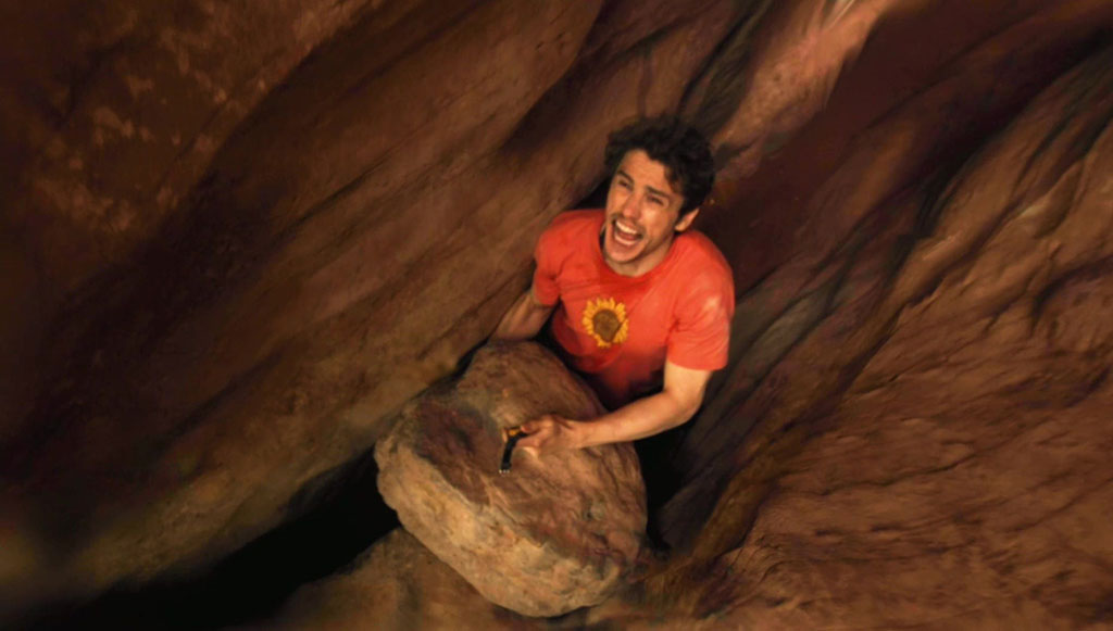 The main character of 127 Hours shouting with his arm stuck between rocks.