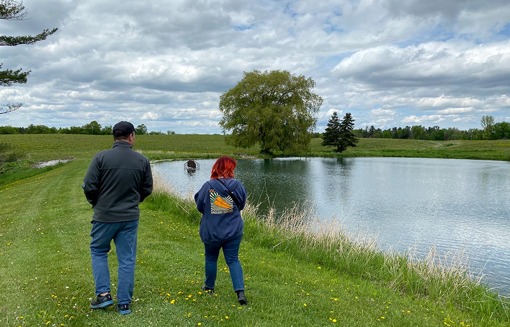 Two people walking around a pond