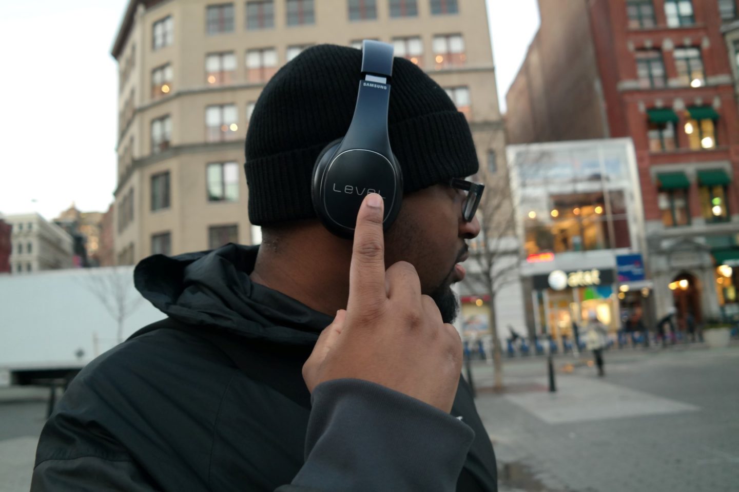 Guy wearing wireless bluetooth headphones downtown