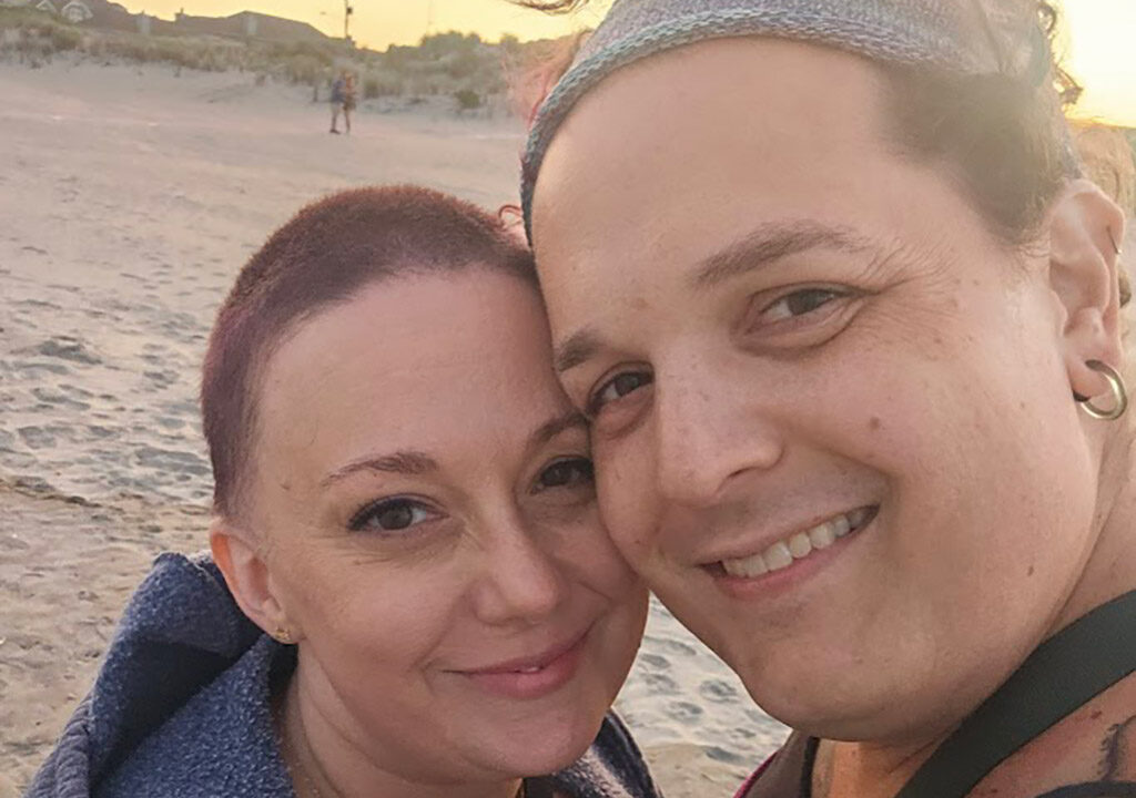 Corry and Bethany smiling for a selfie on the beach