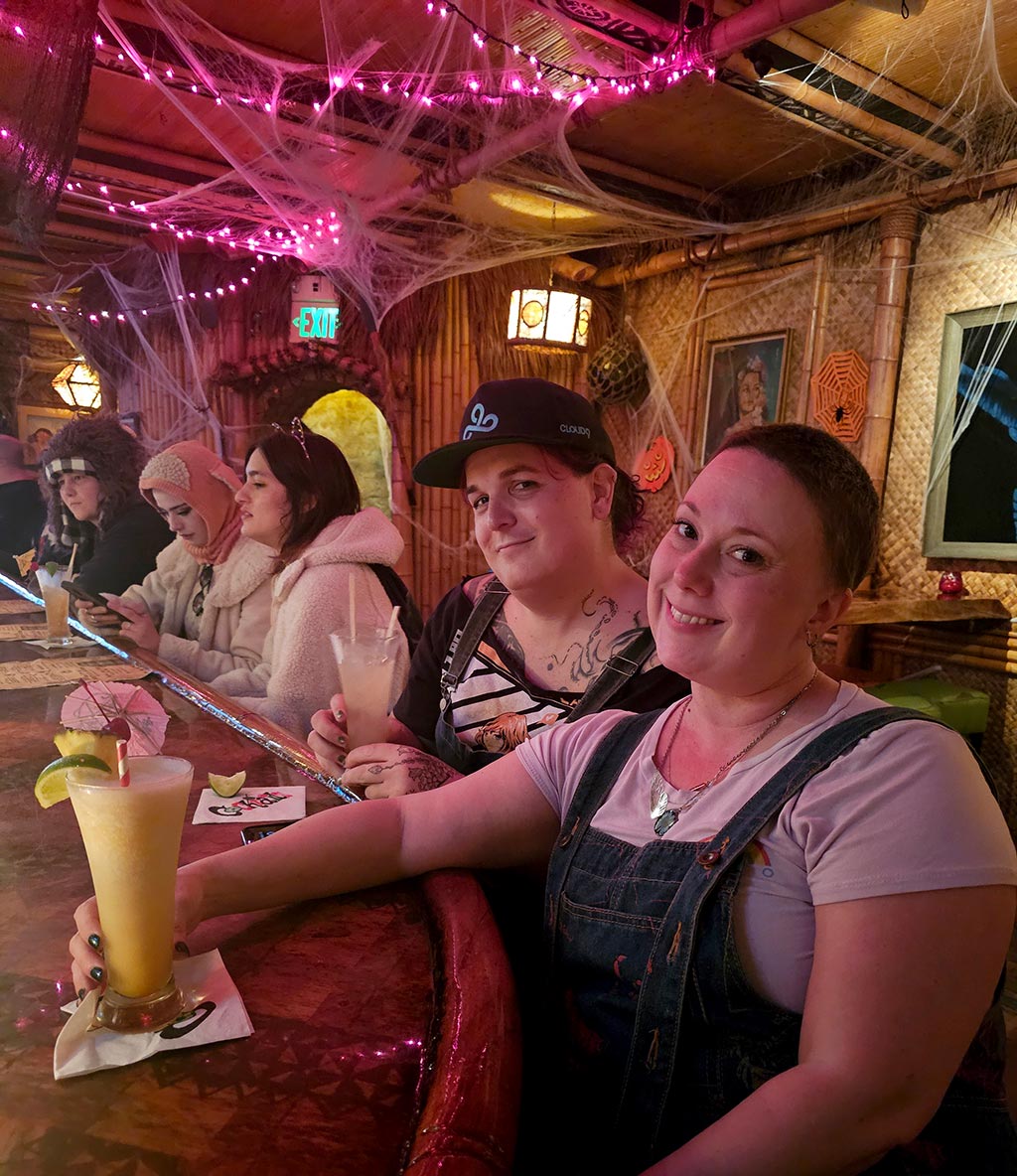 Corry and Bethany smiling, enjoying tiki drinks at Kona Cafe when friends from out of town visited.