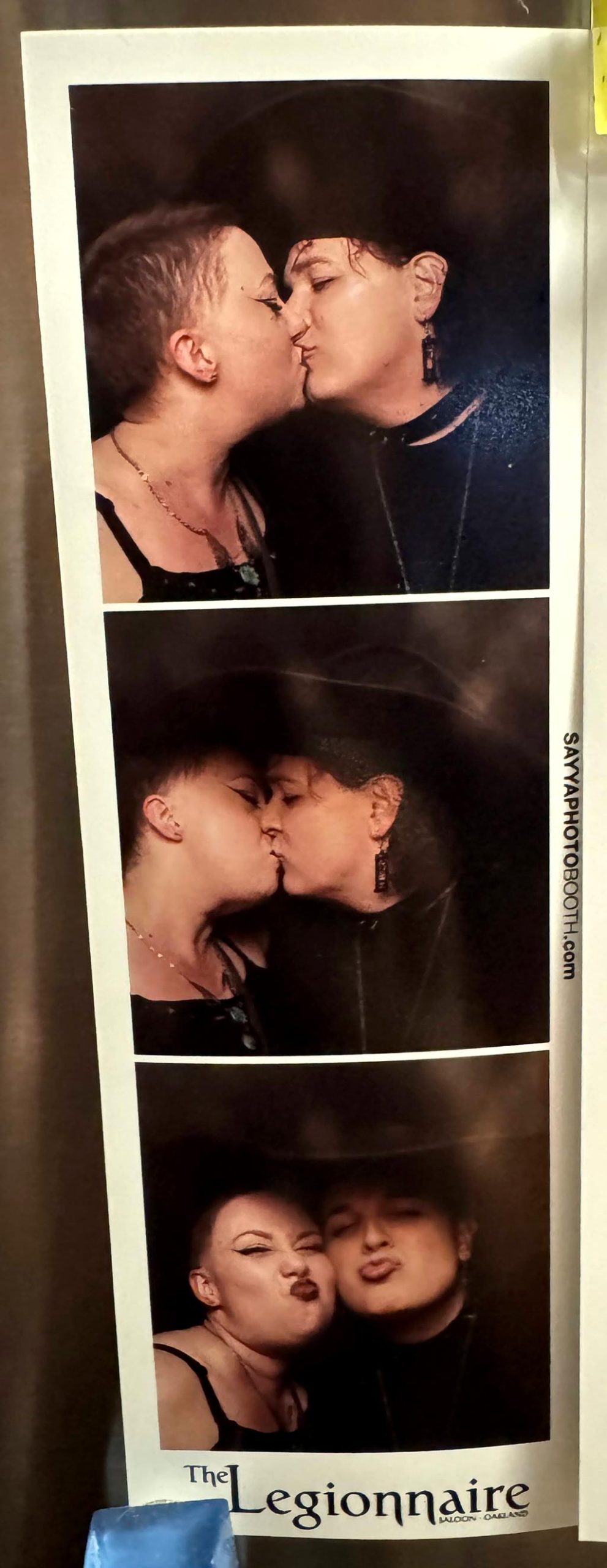 Three photobooth photos of Corry and Bethany wearing witchy outfits for Halloween at The Legionnaire Saloon in Oakland. They're making kissy faces in each one.